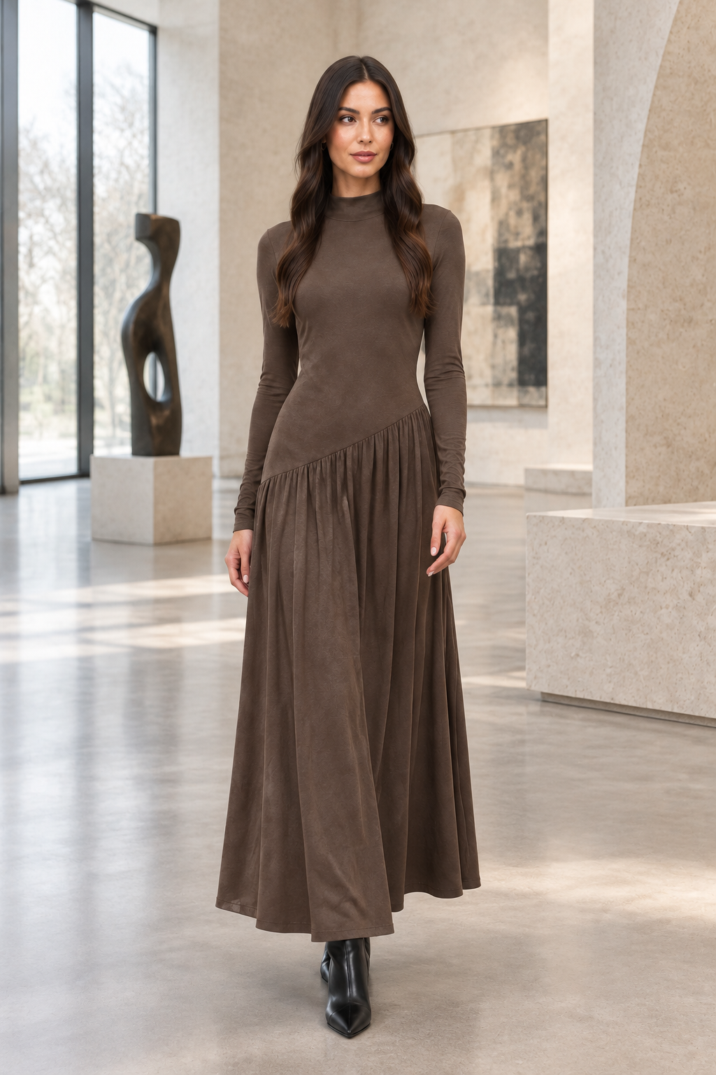 Model draagt Coffee Brown NOVA ELISE asymmetrische jurk in een moderne Nederlandse kunstgalerie