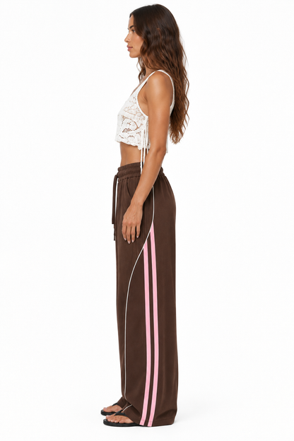 Zijaanzicht van Nova Elise wide-leg broek met zijstrepen op model tegen witte achtergrond